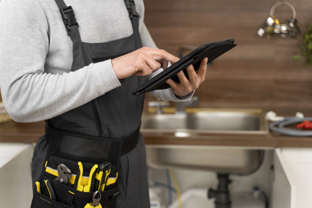 A professional plumber conducting a regular plumbing inspection in a residential home